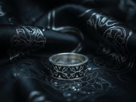 A detailed macro shot of a sterling silver engagement ring. The focal point is a round, honey-colored gemstone (Citrine or Madeira Topaz) set flush into the band. The shank is decorated with a continuous relief pattern of spirals and circles, mimicking the decorative robes found in Gustav Klimt's "Golden Phase" paintings. The silver features an oxidized finish, creating a dark background that makes the polished spirals pop.