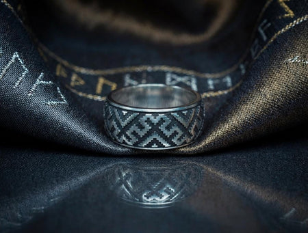 A detailed profile shot of a wide sterling silver ring featuring a repeating "step" or "zig-zag" pattern. The design wraps seamlessly around the entire band. The raised geometric lines are highly polished, catching the light, while the recessed areas are treated with a matte black oxidation. This creates a high-contrast, graphic look similar to a digital pixel pattern or traditional cross-stitch embroidery.