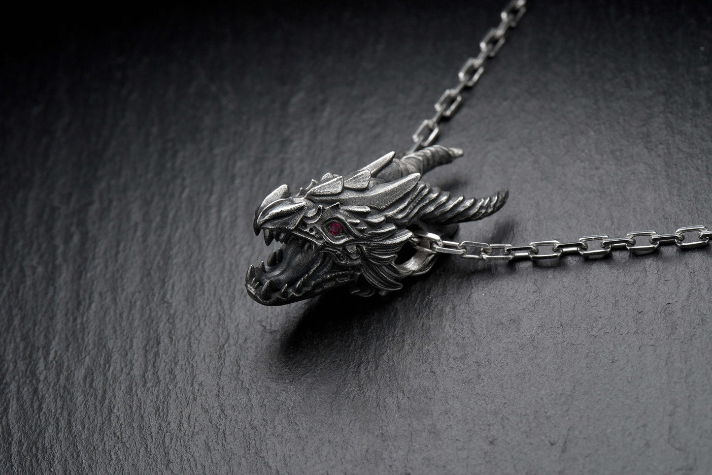 Unleash the power of the dragon with this handmade Screaming Dragon Head Pendant – a bold statement piece forged in solid sterling silver. Perfect for fantasy lovers, Viking culture fans, and anyone drawn to the mystique of mythical beasts, this pendant captures a fierce dragon mid-roar, its jaw open and a glowing ruby-red eye burning with intensity. (etsy image id: 4413227535)