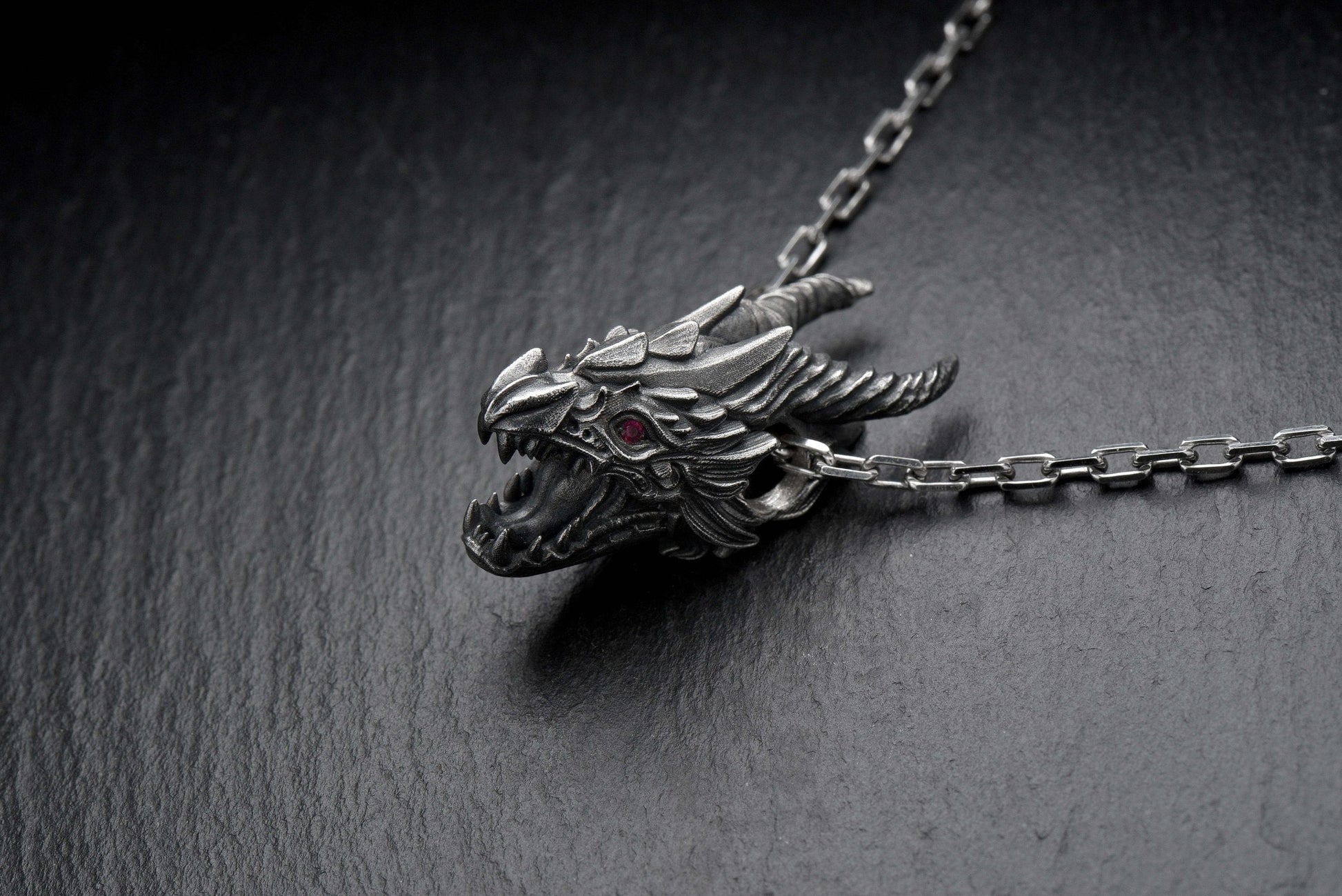 Unleash the power of the dragon with this handmade Screaming Dragon Head Pendant – a bold statement piece forged in solid sterling silver. Perfect for fantasy lovers, Viking culture fans, and anyone drawn to the mystique of mythical beasts, this pendant captures a fierce dragon mid-roar, its jaw open and a glowing ruby-red eye burning with intensity. (etsy image id: 4413227535)