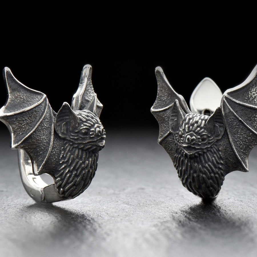 May include: A pair of silver earrings shaped like bats with detailed wings and faces. The hinged plug design allows them to sit securely and closely against the earlobe. Bathed in moody, low-key lighting, these gothic earrings evoke a mystical, nocturnal atmosphere perfect for a dark romance aesthetic. The beautifully detailed silver plug bat earrings capture the essence of vampirecore and whimsigoth fashion. (etsy image id: 5276595997)