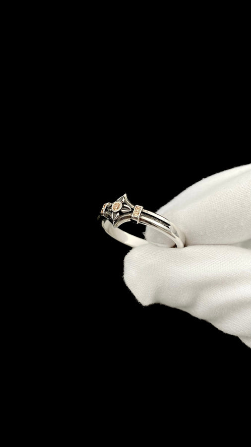 A high-resolution macro photograph of a matching sterling silver gothic wedding ring set resting on softly draped, luxurious white satin. The set features a wider masculine band and a slightly narrower feminine band. Both rings display a continuous engraved arcade of pointed medieval arches along the bottom edge, centering on a polished geometric rhombus frame that holds a brilliant round white gemstone. The polished silver beautifully contrasts  (etsy image id: 7928017042)