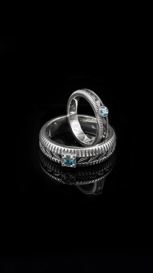 A nature-inspired silver wedding ring featuring raised leaf motifs and a shimmering round gemstone set in the center. The Art Nouveau style is expressed through smooth curves and organic detailing along the band. Ideal for brides or grooms who appreciate delicate plant symbolism, handcrafted jewelry, and an elegant blend of vintage and contemporary design elements in their wedding set. (etsy image id: 6300134508)