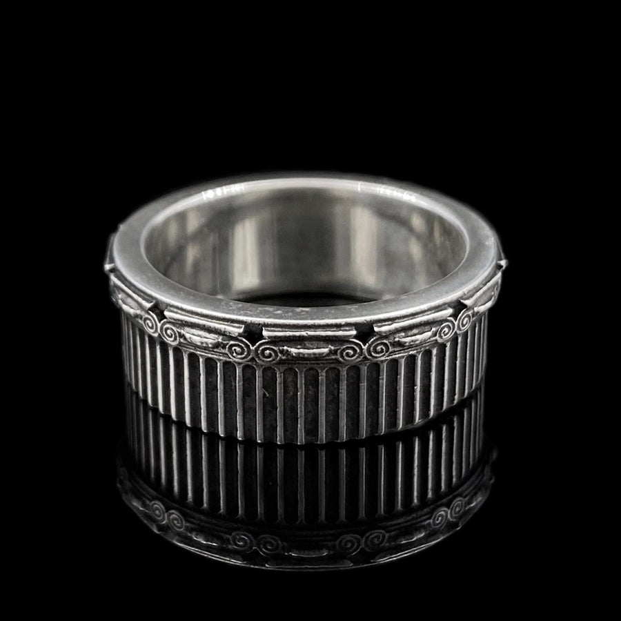 A polished sterling silver wedding band inspired by historical Greek architecture, featuring full-length vertical column lines and detailed Ionic scrollwork. The ring’s reflective interior contrasts with the textured exterior, emphasizing craftsmanship and depth. This Art Deco–style temple band is ideal for those who love structural jewelry rooted in ancient culture and timeless design. (etsy image id: 7193919287)