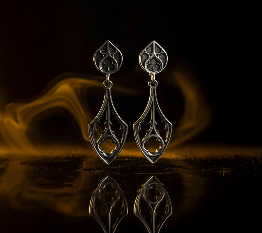 Embrace the dark appeal of gothic fashion with our Sterling Gothic Earrings. Each pair is exquisitely crafted in a gothic style, bringing a touch of mystery and romance to your look. An ideal choice for those who appreciate dark shades of elegance. The image highlights the high-contrast finish of the 925 sterling silver. The "relief" casting gives the tracery lines a three-dimensional quality, mimicking carved stone. (etsy image id: 6150699379)