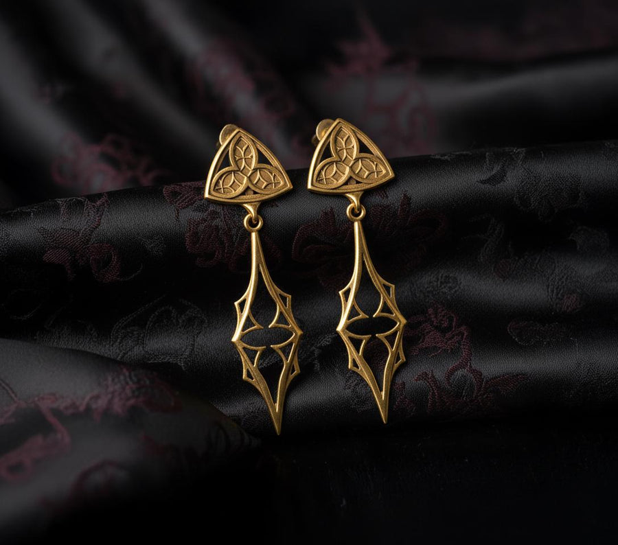 Embrace your dark beauty with our Gothic silver earrings. Unique design, premium silver, intricate details, and comfortable to wear.
A sharp studio shot of a pair of articulated silver earrings. The top stud is a soft triangle shape containing a raised "trefoil" or "trinity" knot pattern against a textured background. The bottom section is an elongated, openwork drop that tapers to a sharp point, resembling a Gothic spire or a (etsy image id: 7218877462)