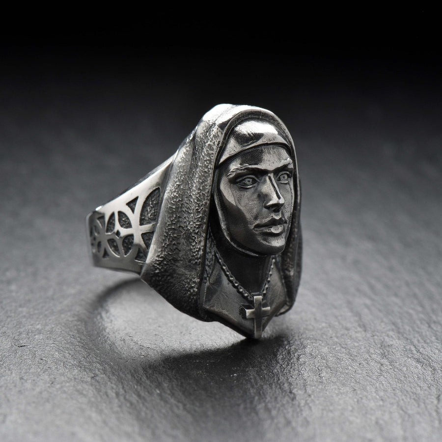Crafted with meticulous attention to detail, this ring features a beautifully sculpted nun figure with a serene expression. The delicate design showcases the flowing robes and the distinct features that represent the dedicated life of a nun.