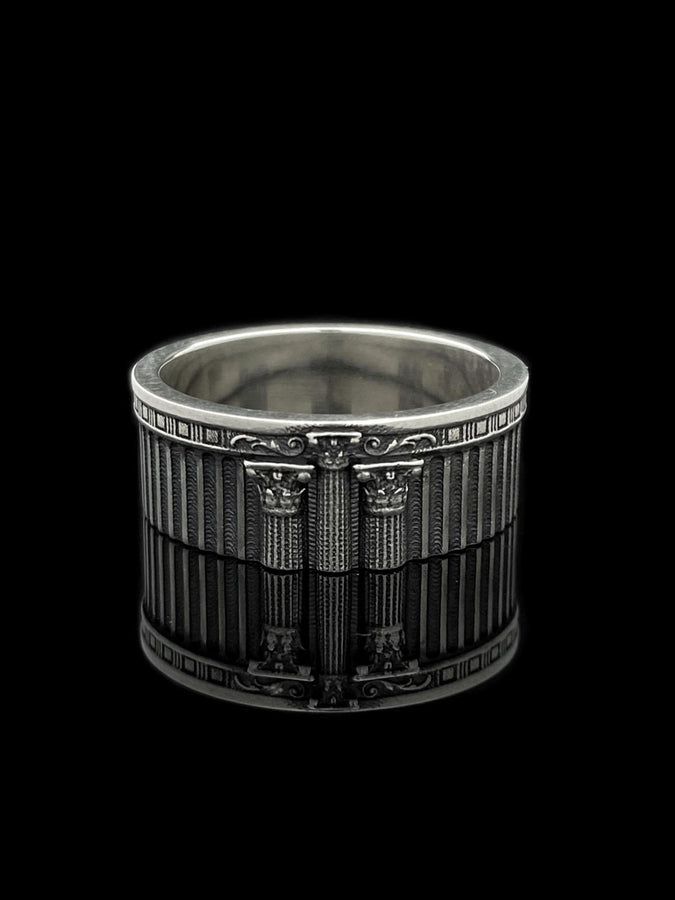 This sterling silver ring set features bold architectural column details with finely carved fluting and ornate capital motifs. The design draws inspiration from ancient Greek and Roman structures, offering a sculptural aesthetic that feels elegant and timeless. Ideal for wedding sets or collectors of detailed art jewelry, the polished silver contrasts beautifully with the deep engraved textures.
