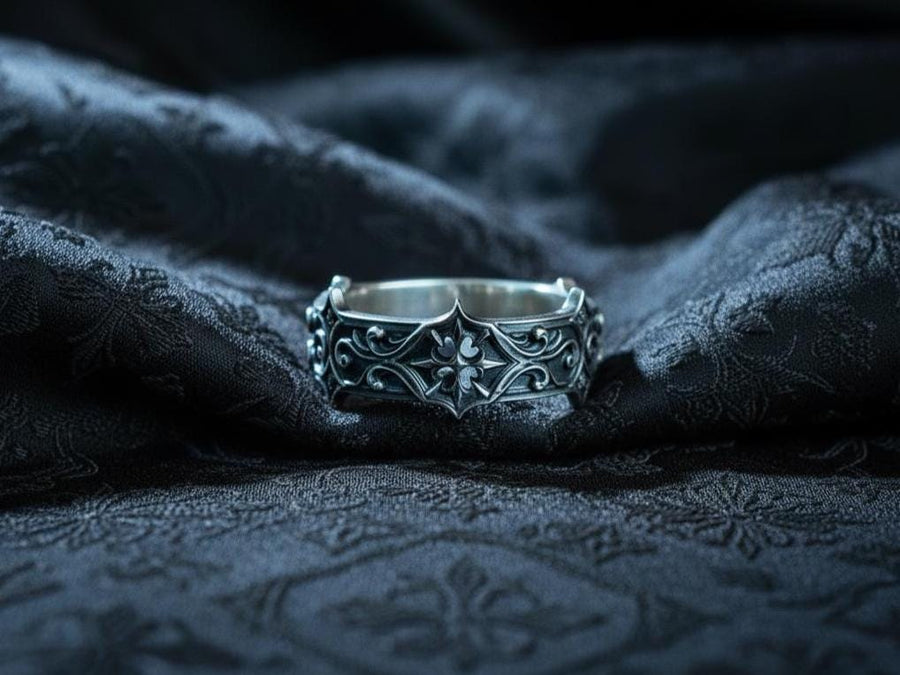 Handmade sterling silver band with an intricate gothic crown motif in the center, framed by swirling ornamental engravings. The deep relief and antique darkened finish evoke historic cathedral carvings. Ideal for customers seeking dark romantic jewelry, gothic accessories, medieval wedding rings, and meaningful silver bands with symbolic architecture-inspired designs. (etsy image id: 7423455351)