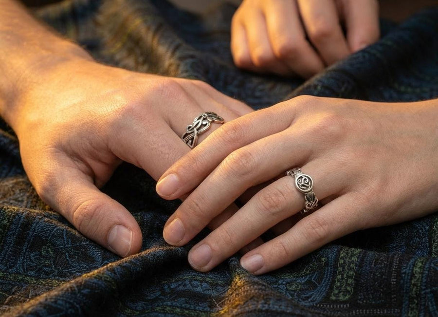 A cinematic close-up of a sterling silver ring lying on a reflective surface. The band features an "openwork" design, meaning the Celtic knot pattern is cut out, allowing light to pass through the loops. The silver strands weave over and under in a continuous infinity motif. The background is dark, but the ring is illuminated by a warm, golden mist. (etsy image id: 7442429936)