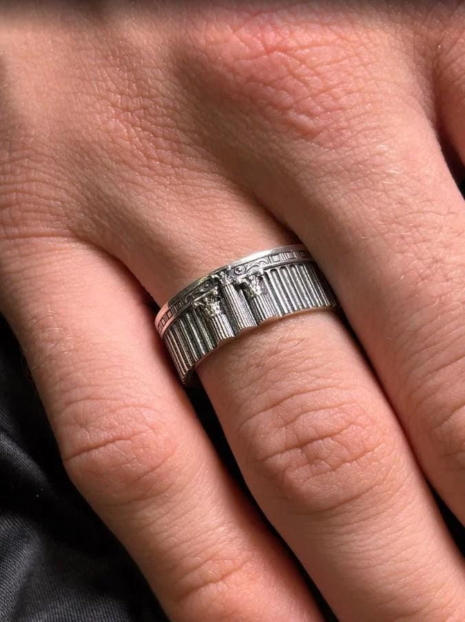 This sterling silver ring set features bold architectural column details with finely carved fluting and ornate capital motifs. The design draws inspiration from ancient Greek and Roman structures, offering a sculptural aesthetic that feels elegant and timeless. Ideal for wedding sets or collectors of detailed art jewelry, the polished silver contrasts beautifully with the deep engraved textures.