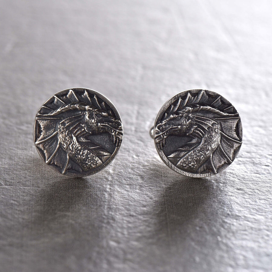 May include: A pair of silver cufflinks featuring a detailed dragon head design. (etsy image id: 7689558200)