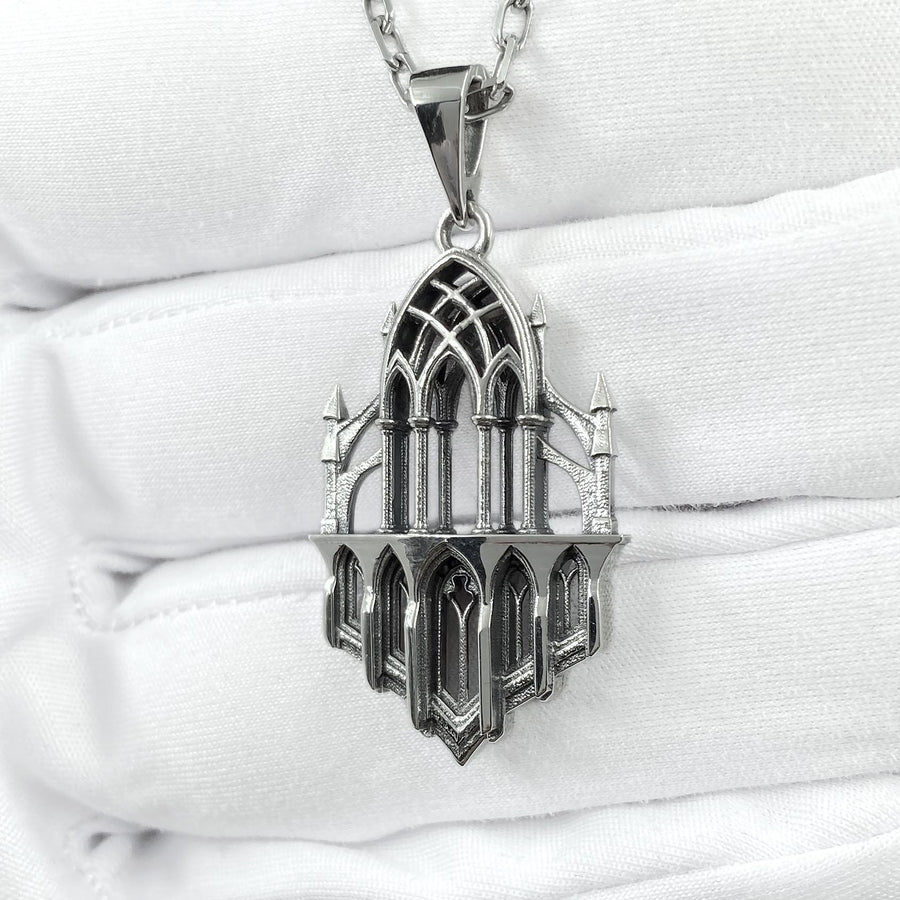 This macro image highlights the masterful craftsmanship of the solid 925 sterling silver casting. The artisan has flawlessly translated monumental stone architecture into miniature metalwork. The columns are smooth and precise, while deep sulfur oxidation creates a permanent matte black shadow in the open recesses of the arches. This traditional antiquing technique gives the gothic relic pendant the weathered, enduring texture of an actual historical cathedral fragment. (etsy image id: 7979026828)