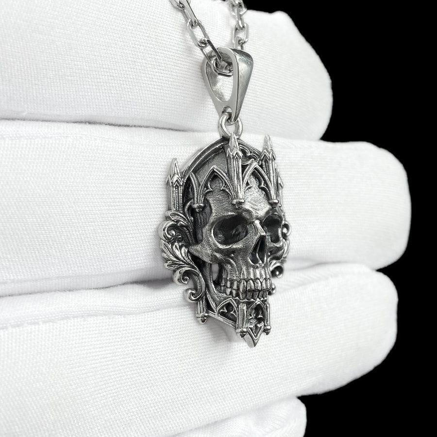 This macro image highlights the masterful texturing of the solid 925 sterling silver casting. The artisan has beautifully captured the smooth, anatomical curves of the organic skull, contrasting them against the rigid, geometric lines of the gothic tracery and cathedral spires. A deep sulfur patina treatment provides permanent matte black shadows, giving this wearable sculpture the rugged, weathered patina of a genuine historical artifact. (etsy image id: 7979410208)
